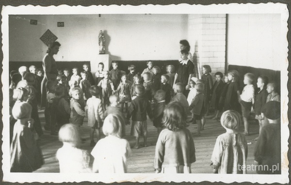 Dzieci z ochronki nr 2 w Lublinie podczas zajęć ruchowych w sali z dużym piecem