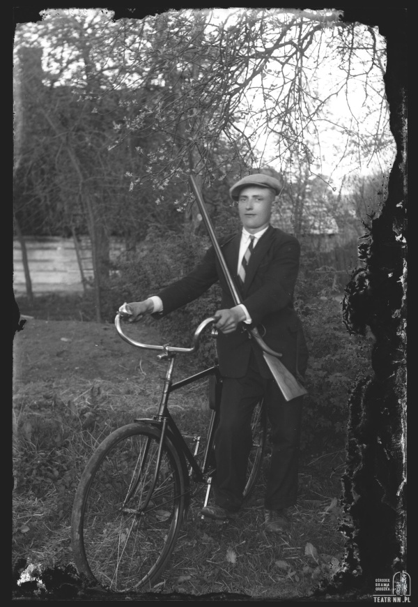 Mężczyzna ze strzelbą i rowerem