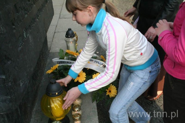 Uczennica ze Szkoły Podstawowej nr 24 w Lublinie stawia znicz przed Pomnikiem Ofiar Getta - "Listy do Henia" 2007