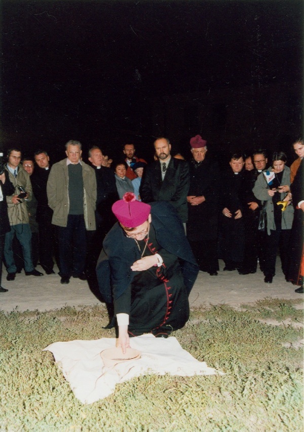 Arcybiskup Józef Życiński wykopuje ziemię z miejsca po kościele farnym podczas Misterium "Jedna Ziemia - Dwie Świątynie"