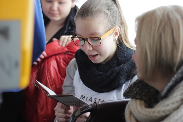 Uczniowie z Gimnazjum nr 19 czytają w autobusie wiersze Czechowicza