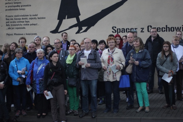 Uczestnicy spaceru trasą "Poematu o mieście Lublinie" na tle muralu promującego wydarzenie
