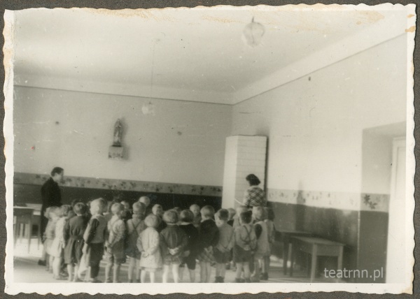 Dzieci z ochronki nr 2 w Lublinie wraz z wychowawczyniami w sali z dużym piecem