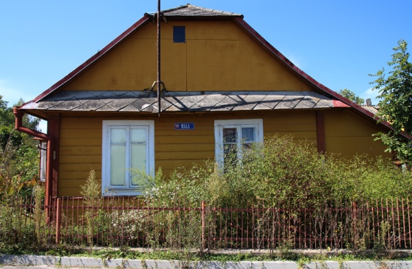 Ściana szczytowa domu drewnianego przy skrzyżowaniu ulicy 3 Maja i Małej w Tyszowcach